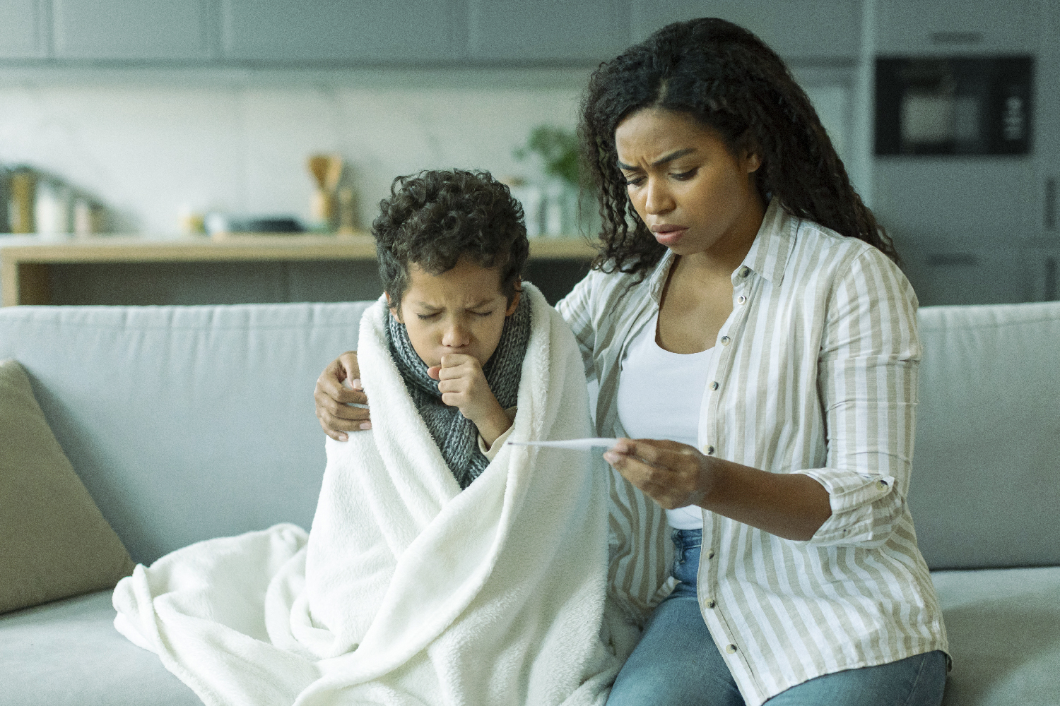 En la imagen vemos a una mamá cuidando a su hijo que está enfermo y no tiene un seguro de salud.