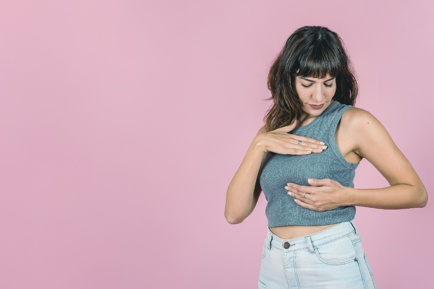 Vemos a una chica haciendo los masajes en el pecho para hacer la prevención frente al cáncer de mama.
