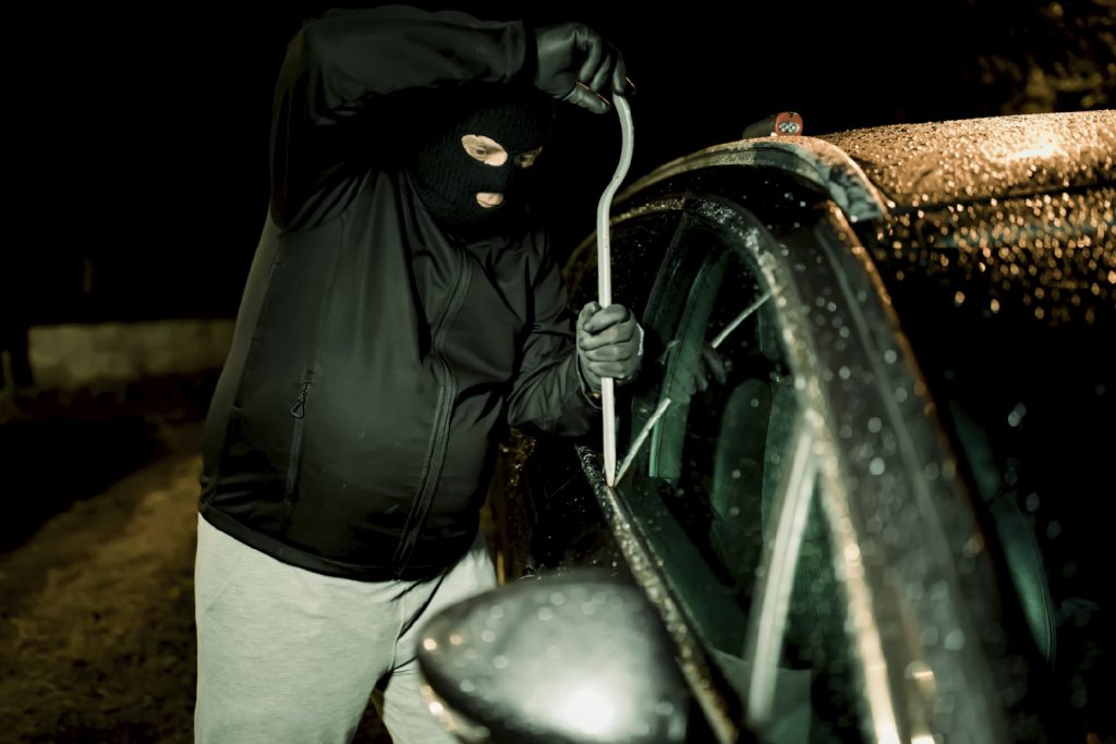 Ladrón robando auto que no está asegurado con seguro vehicular.