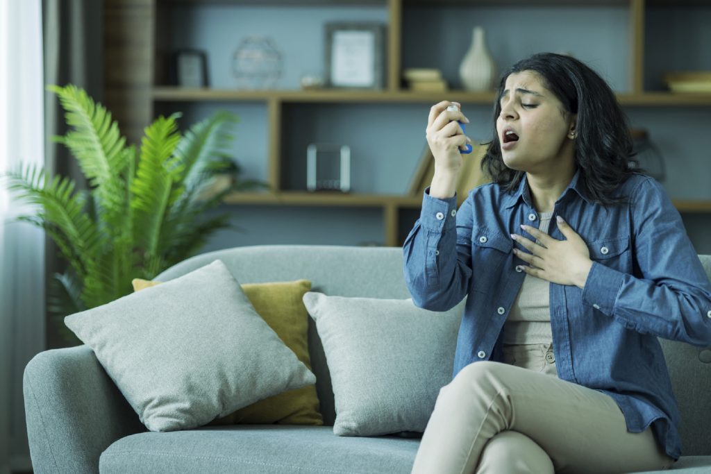 Mujer con inhalador en pleno ataque de asma