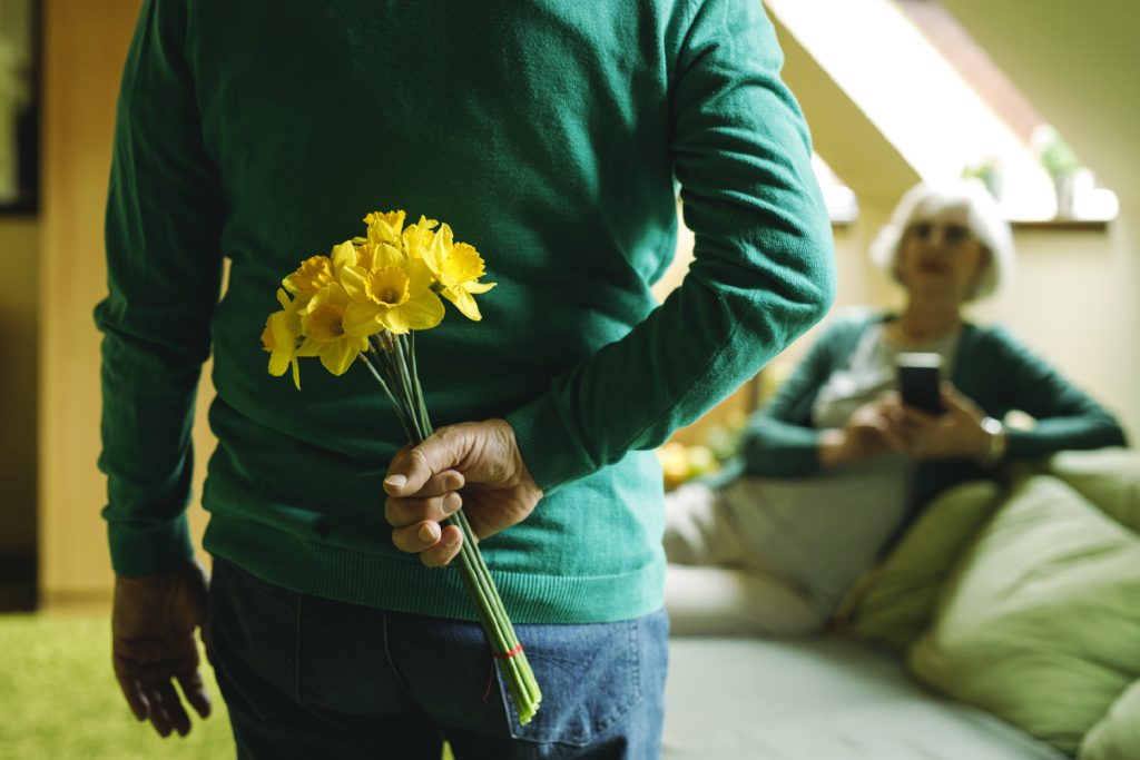 Hombre entregando flores amarilla a su pareja.