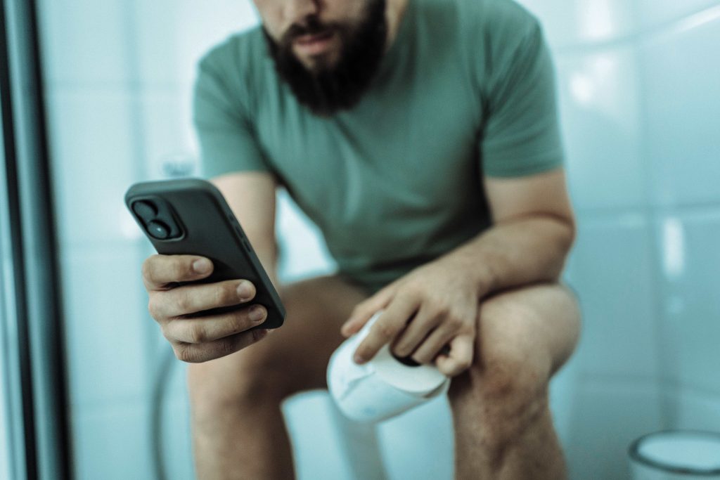 Hombre usando el celular en el baño más riesgo de sufrir de hemorroides.