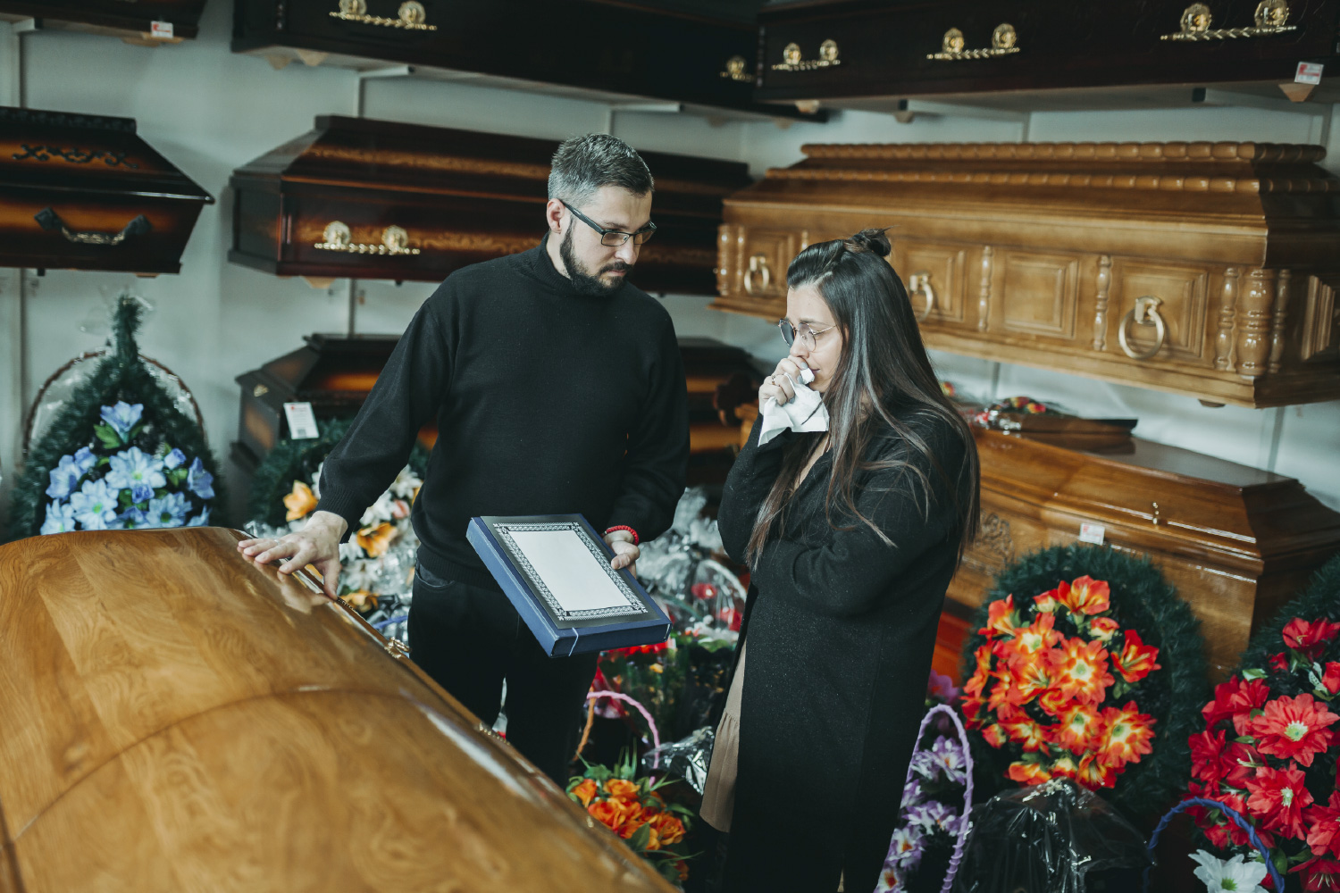 Viuda eligiendo los arreglos para el funeral de su esposo cubierta por seguro de sepelio.