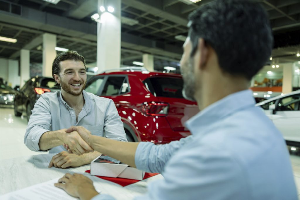 Hombre contratando seguro vehicular para su auto nuevo