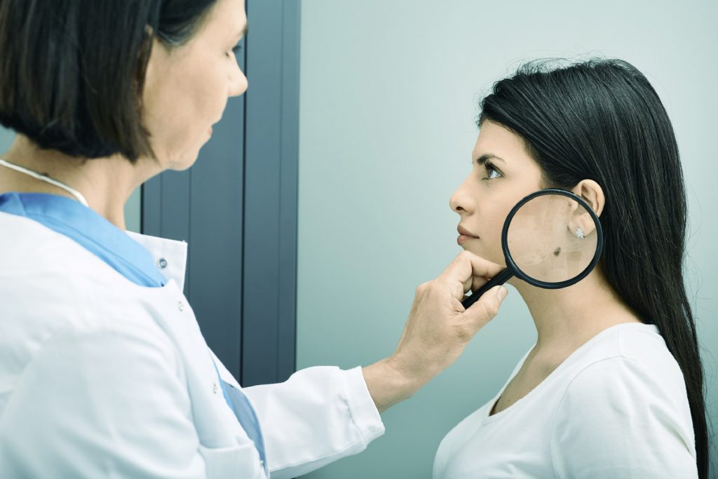 Mujer en el doctor revisándose cambios en lunares