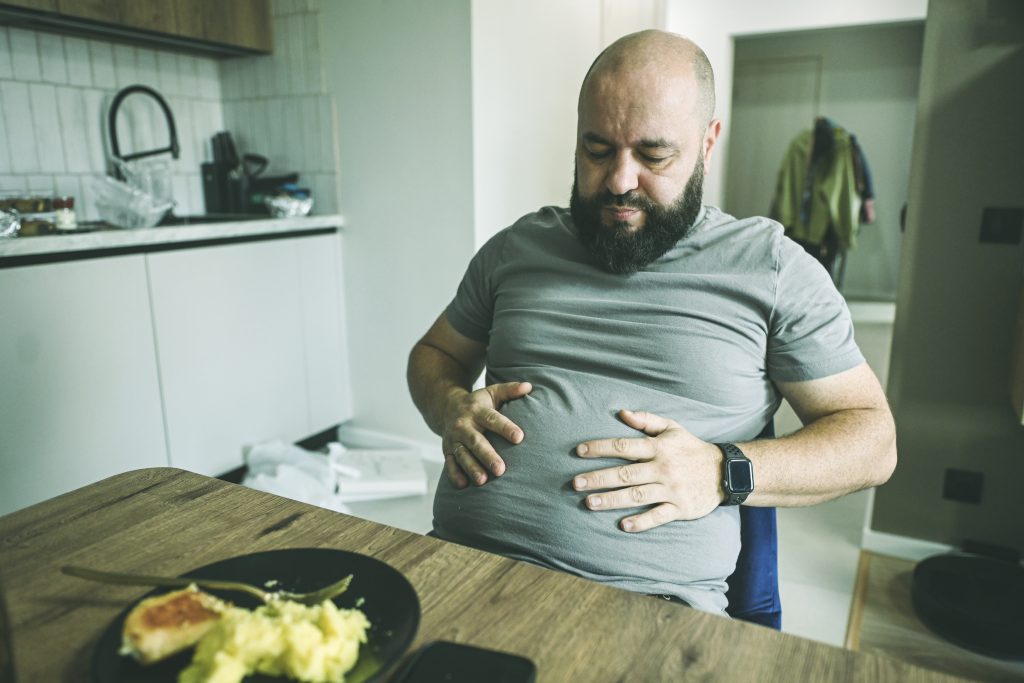 hombre comiendo con problemas de salud intestinal