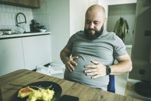 hombre comiendo con problemas de salud intestinal