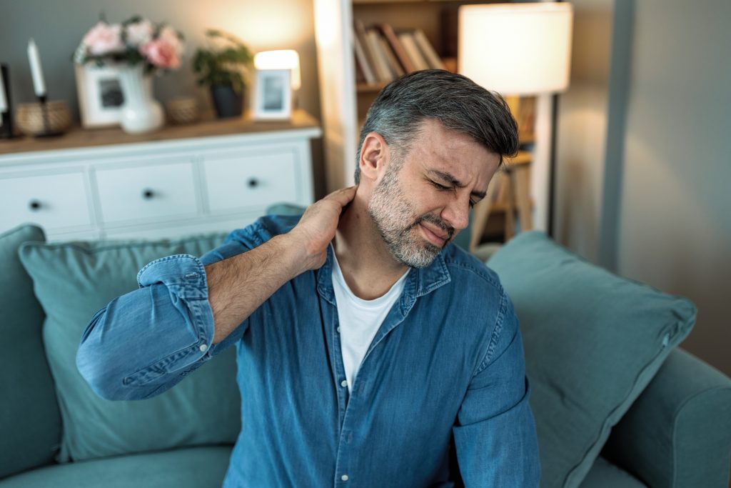 Hombre con dolor de cuello por ejercicios en casa