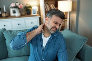 Hombre con dolor de cuello por ejercicios en casa