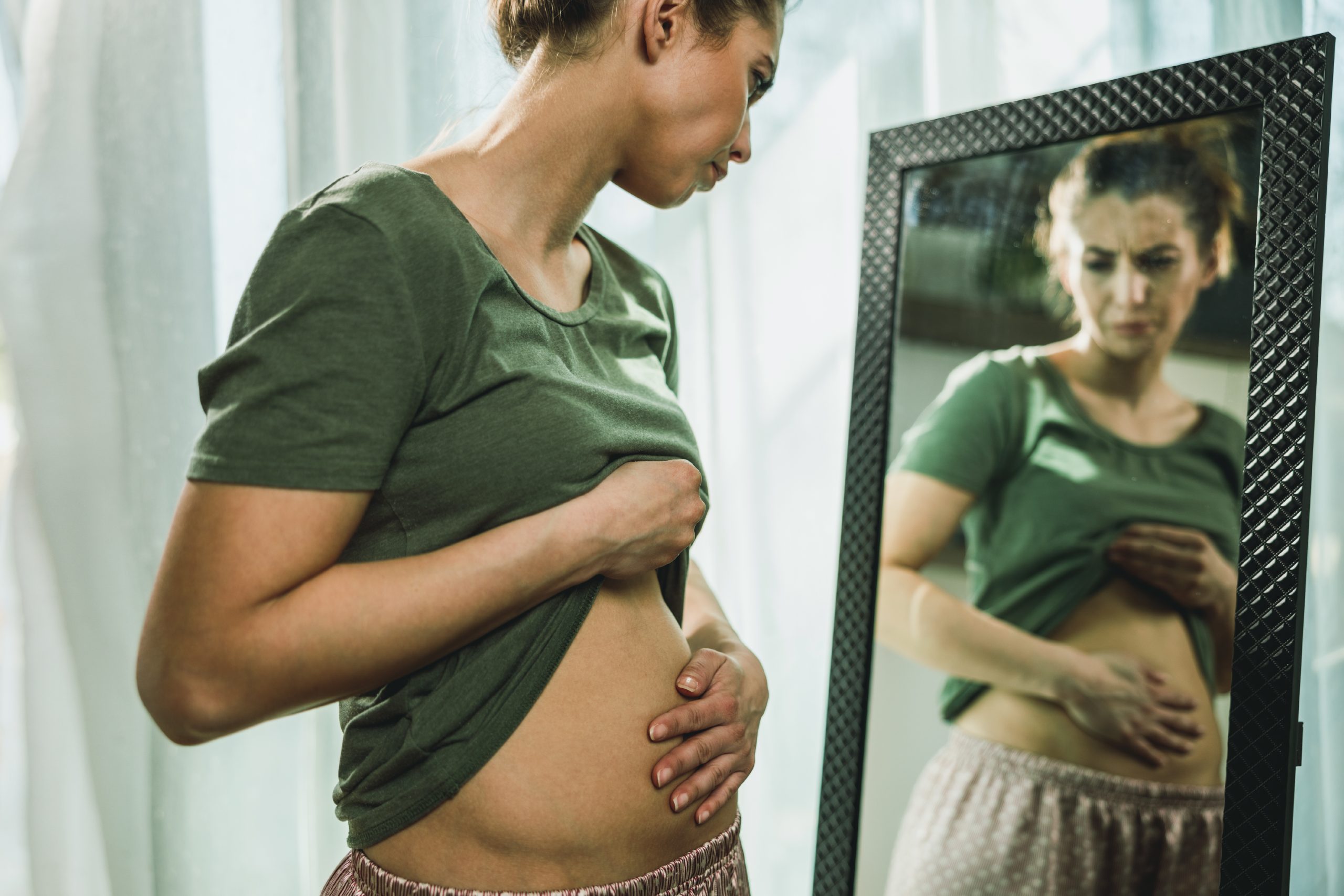 mujer con el abdomen hinchado después de comer