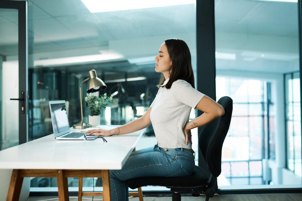 Mujer que pasa muchas horas sentadas sufriendo de sedentarismo