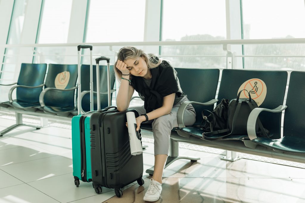 Mujer sin seguro de viaje esperando en aeropuerto